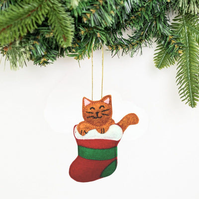Cat in a stocking Christmas ornament hanging on a tree.