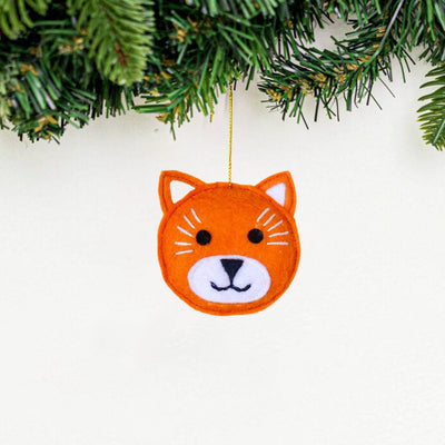 Orange fox ornament hanging from a Christmas tree.