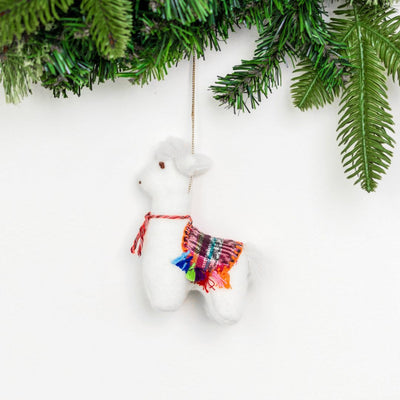 White llama ornament with colorful scarf hanging from Christmas tree