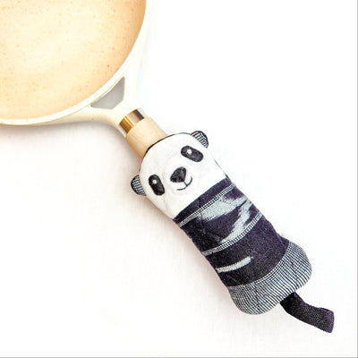 Panda-shaped skillet handle holder on a pan handle with a white background