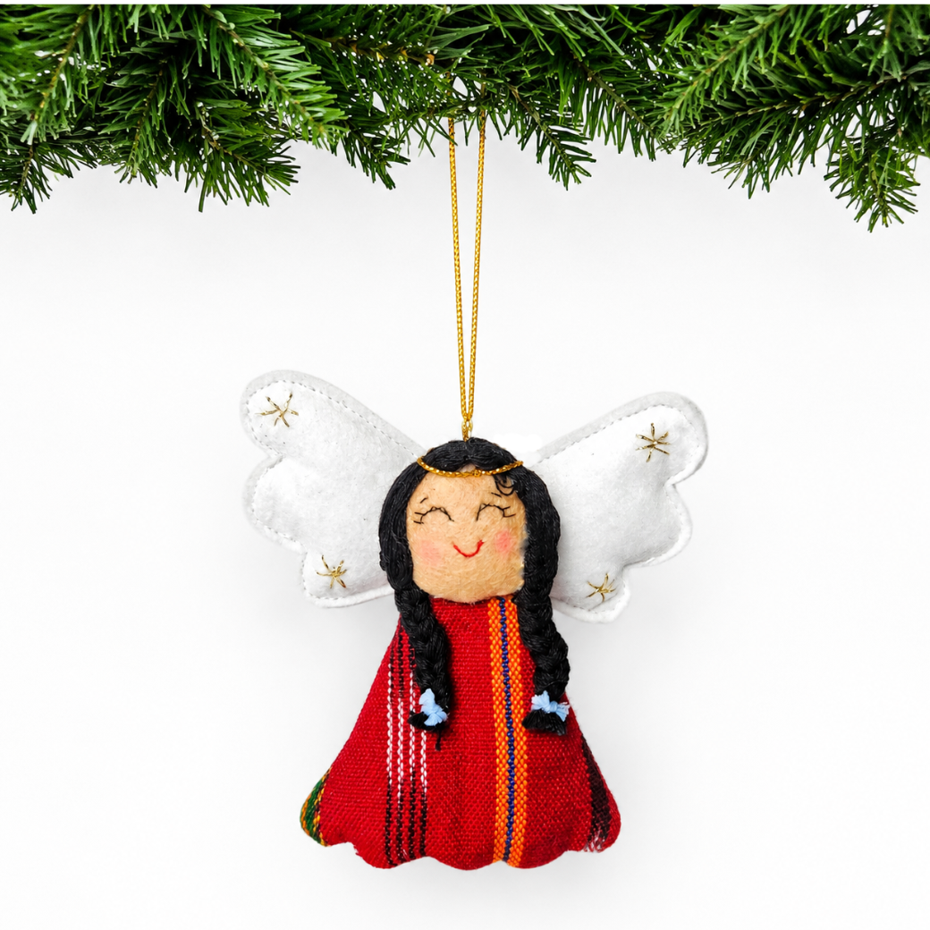 Decorative angel ornament with long hair and red outfit hanging from a tree branch.