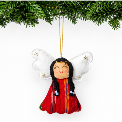 Decorative angel ornament with long hair and red outfit hanging from a tree branch.